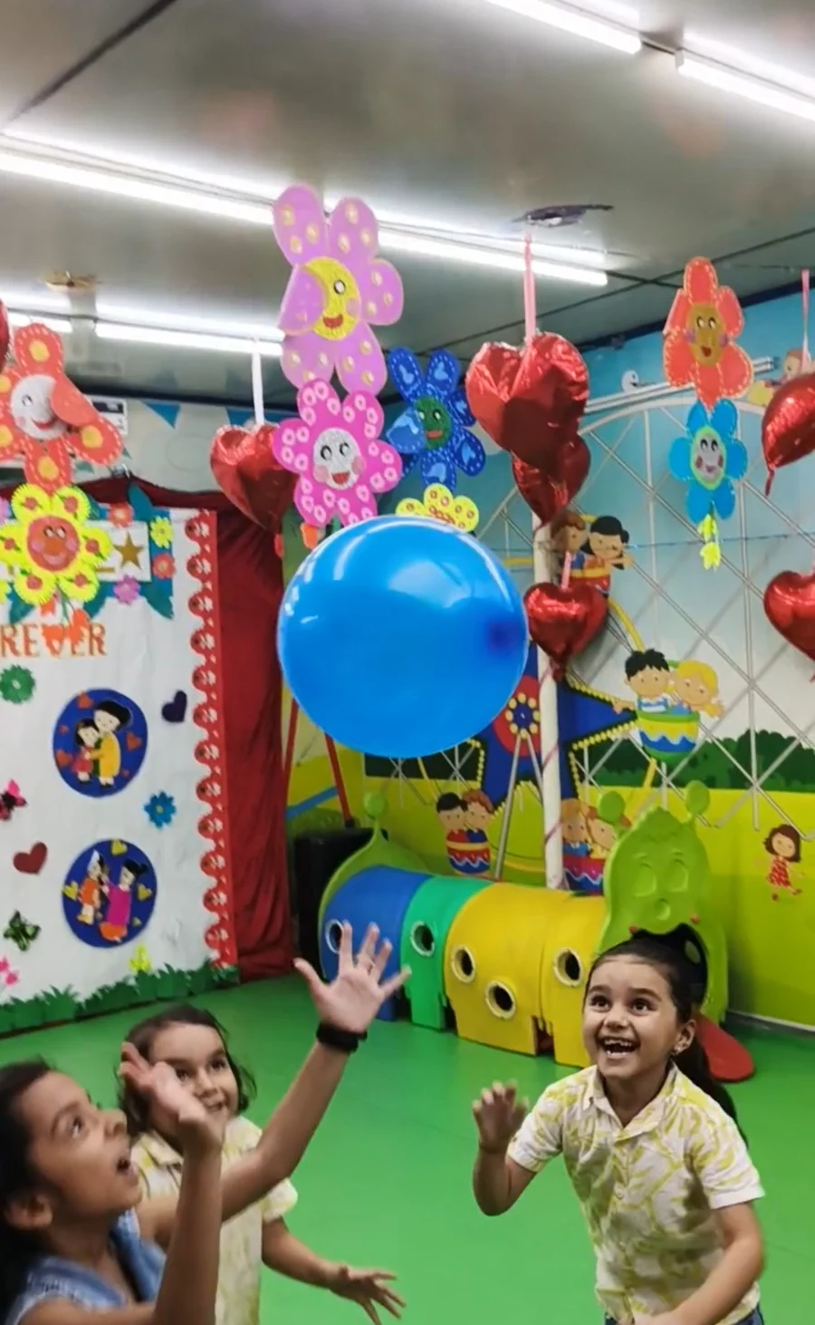 Children playing together with blue balloons