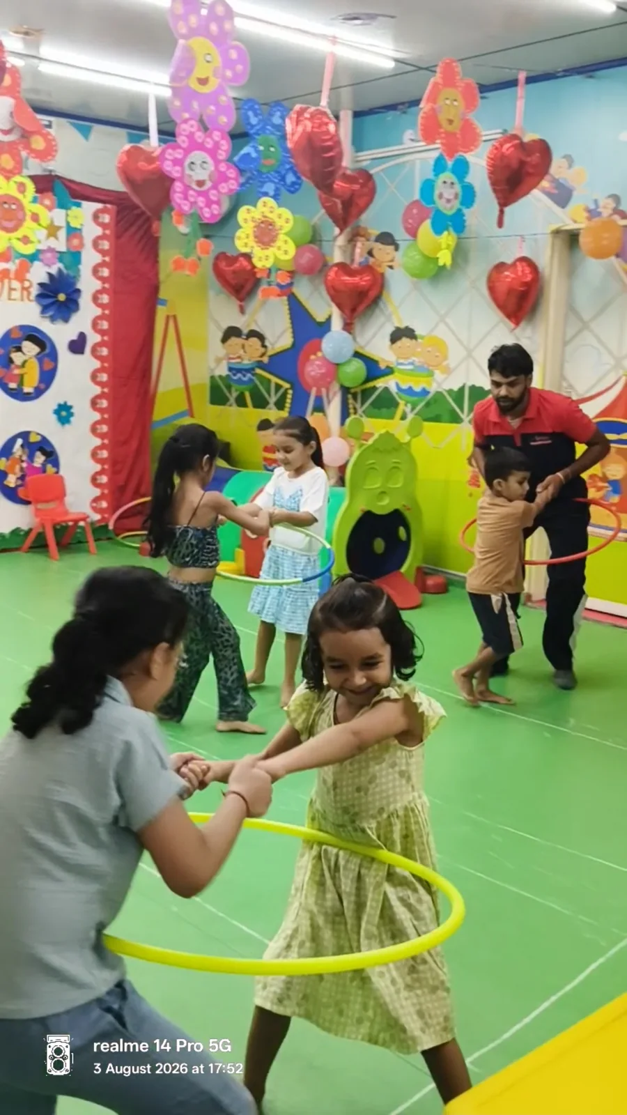 Children playing with hoops alongside an adult